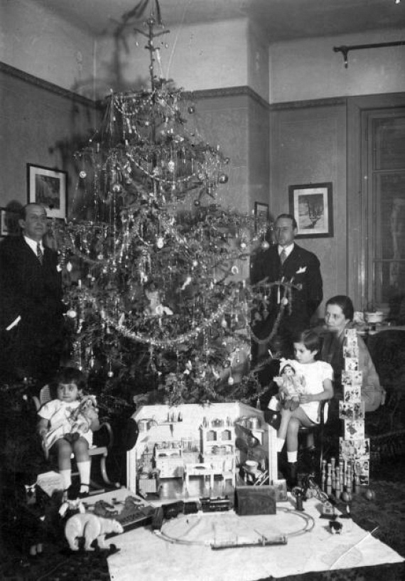 	Pazar babaházat kaptak a kislányok: a család a fát körbeülve fényképezkedett 1930 karácsonyán.	(1930)
