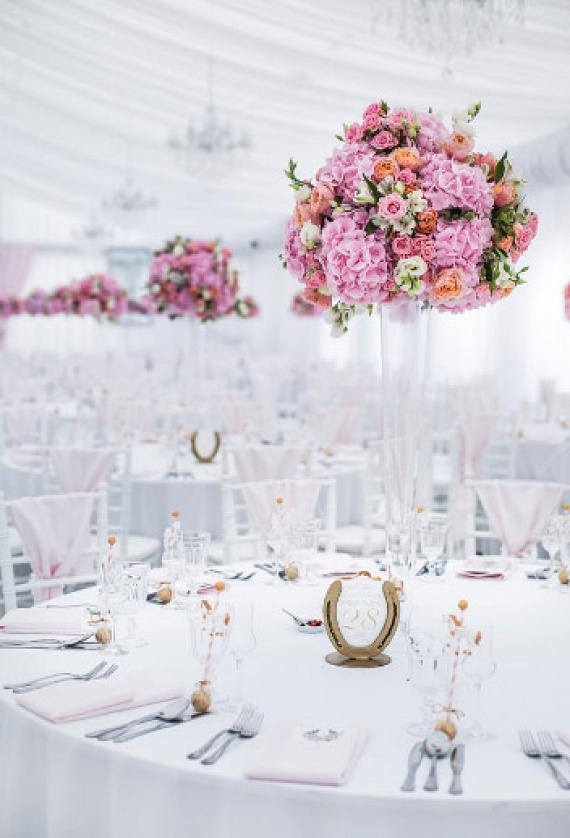 
                        	A fehér mellett a rózsaszín volt az uralkodó szín: négyezer szál  virágból készült a dekoráció. Az asztalokat díszítő patkó sem véletlen: Zsófi és Zsolt a lovaglás szerelmese, kedvenc sportjuk hozta őket össze.