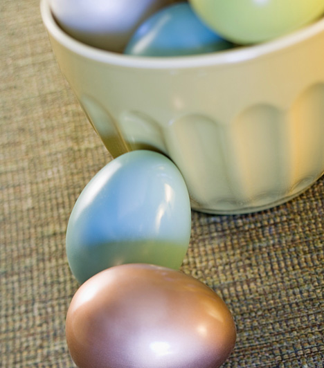 Hamvas-fényes tojásokSemmi nem tiltja, hogy a tojások díszítéséhez olyan anyagokat használj, melyek egyébként nem szokványosak. Gyöngyházfényű festékspray-vel például finom pasztellárnyalatokba öltöztetheted a tojásokat. Érdemes kifújt tojásokat díszítened ezzel a technikával, melyeket felfüggeszthetsz, így a festék mindenhol éri majd a felületet.