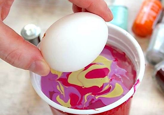
                        	Majd fogd meg a tojás két végét, és forgasd bele a körömlakkos vízbe. Érdemes kicsit várnod, mielőtt kiveszed, hogy a lakk alaposan rátapadjon a héjára.