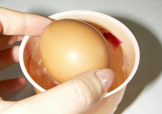 	Fogd meg a tojás két végét, és óvatosan forgasd bele a körömlakkos vízbe. Célszerű 20-ig elszámolni, mielőtt kiveszed, hogy a körömlakk alaposan rátapadjon a héjra.