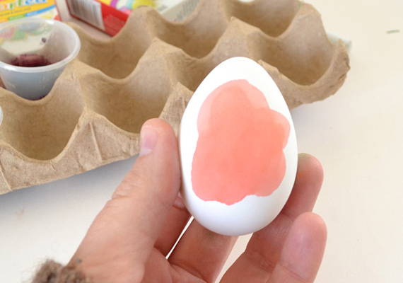 
                        	Fess a tojásra egy nagyobb, tetszőleges színű foltot, például pirosat, ez lesz a virág sziromzata. A szélén hígíthatod egy kicsit a festéket vízzel, így árnyalhatsz is.