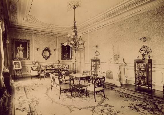 	A képen a mozsgói Biedermann-kastély szalonja látható. A felvétel 1895 és 1899 között készült.