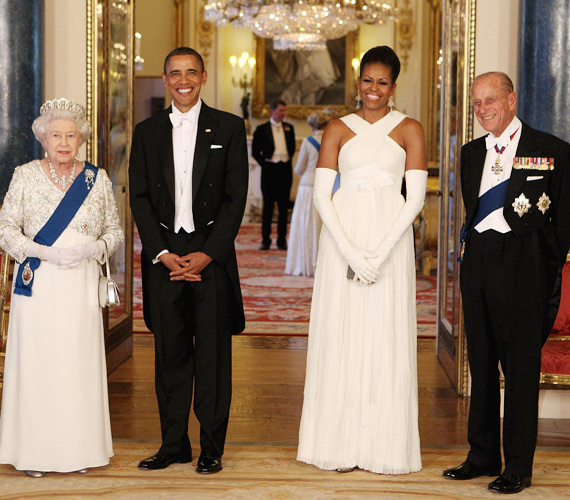 	A királynő sem bírhatta rá a vállak eltakarására. Remekül festett a fehér estélyiben. Az etikettnek a kesztyűkkel tett eleget.