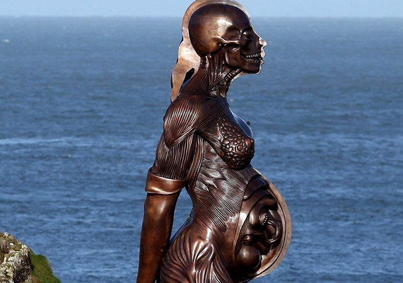 
                        	Jelenleg épp Damien Hirst Angliában, Devonban felállított szobra borzolja a kedélyeket. Az angol kisváros idilljét jól látható helyen egy meztelen, terhes nő 20 méteres szobra töri meg, akinek bőre félig le van fejtve.