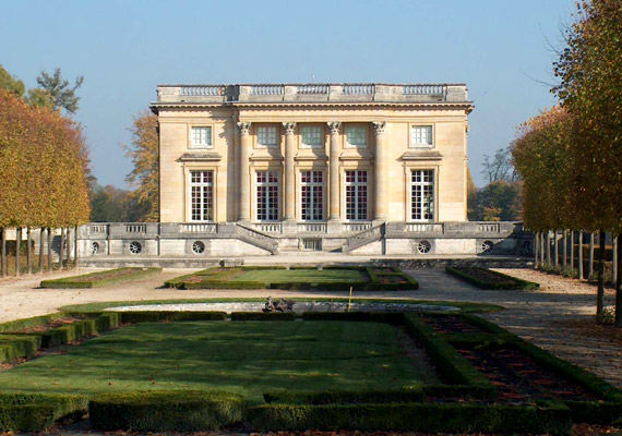 	Az 1768-ban elkészült Kis-Trianon nevű épületet még XV. Lajos, XVI. Lajos nagyapja építtette szeretőjének. XVI. Lajos trónra lépésekor, 1774-ben ajándékozta azt feleségének, a 19 esztendős Mária Antóniának. A kastélyba - mely építészeti szempontból rokokó és klasszicista jegyeket egyaránt magán visel - Mária Antónia hívása nélkül még maga a király sem léphetett be. Mindez természetesen rosszallást váltott ki udvari körökben.